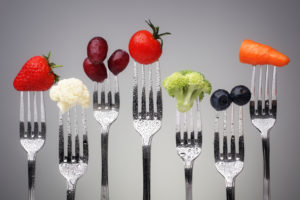 Fruit and vegetable of silver forks against a grey background concept for healthy eating, dieting and antioxidant